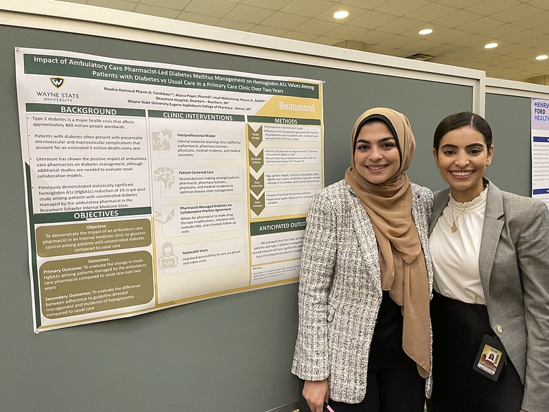 A student and faculty member with poster on College Research Day.