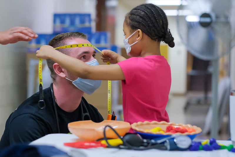 A child measures the head of a Wayne State Physician Assistant student during a Detroit pediatric screening event